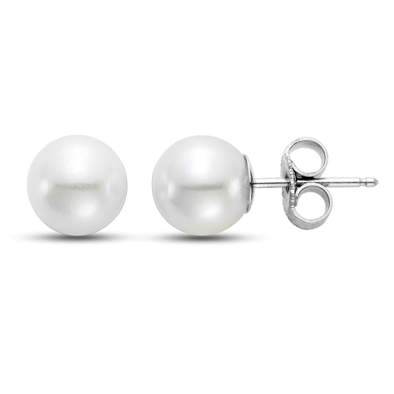 two pearl earrings. one on its side with white gold and the other facing front.