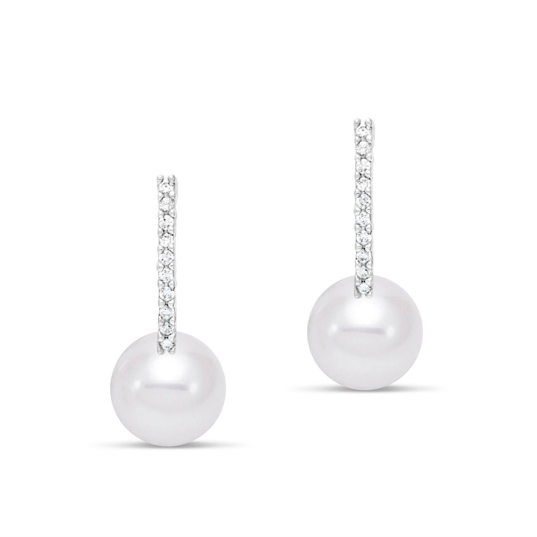 Pair of pearl earrings hanging from diamonds