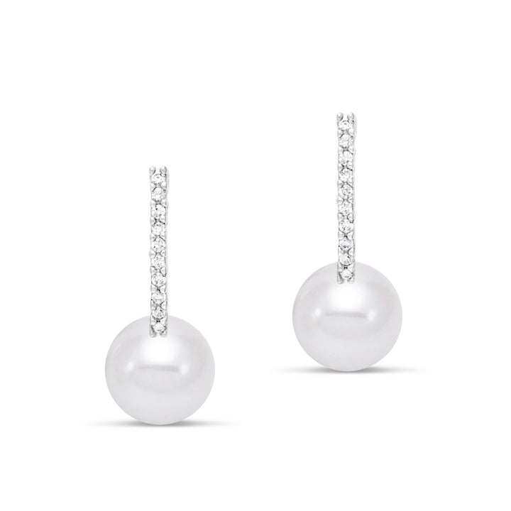 Pair of pearl earrings hanging from diamonds
