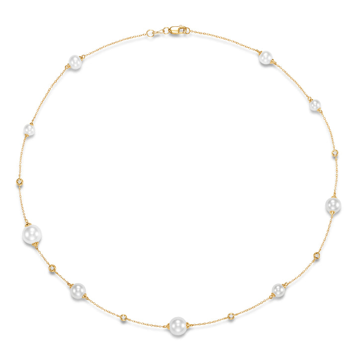 Gold necklace with pearls and diamonds scattered around the gold chain.