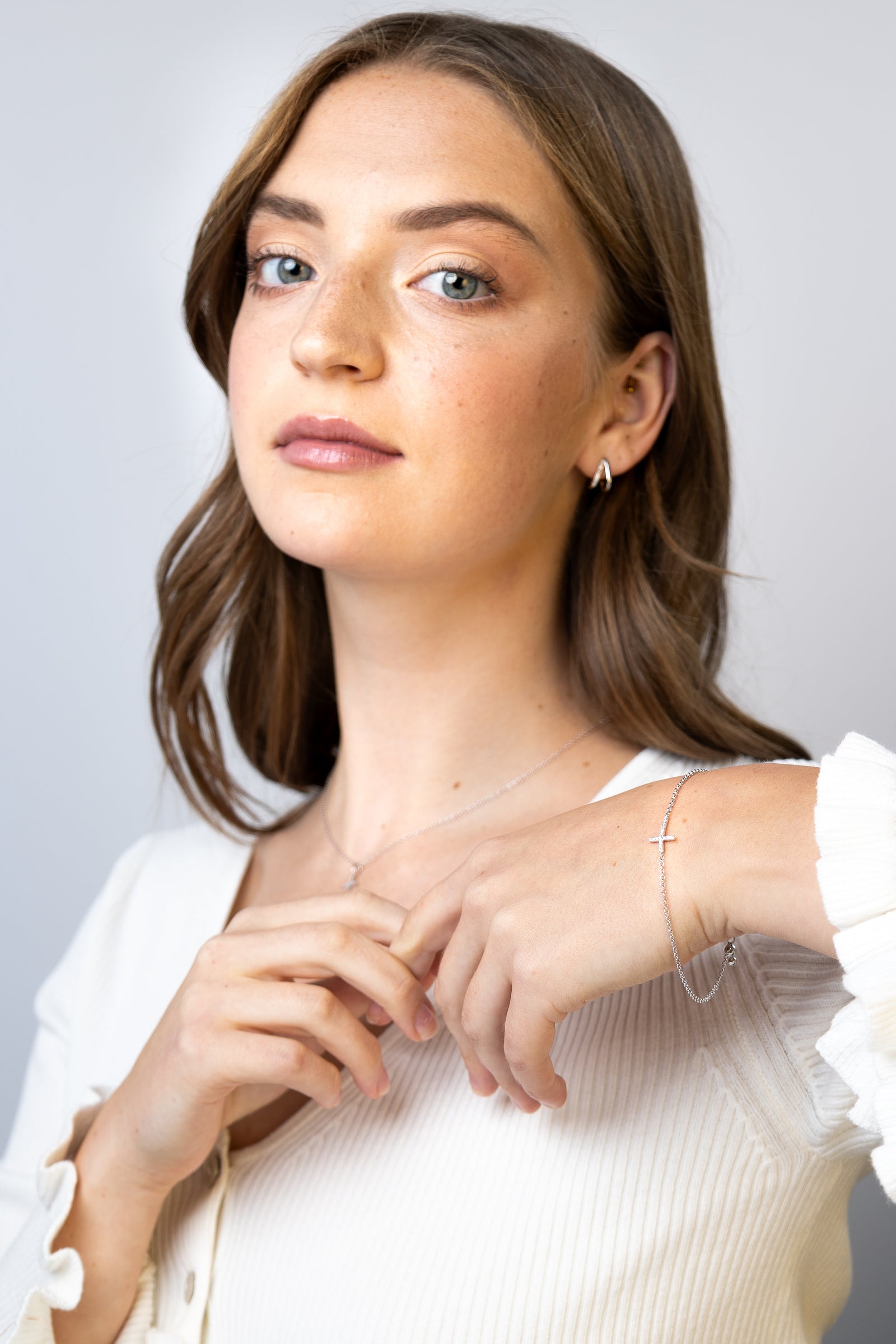 women wearing diamond-white-cross-bracelet