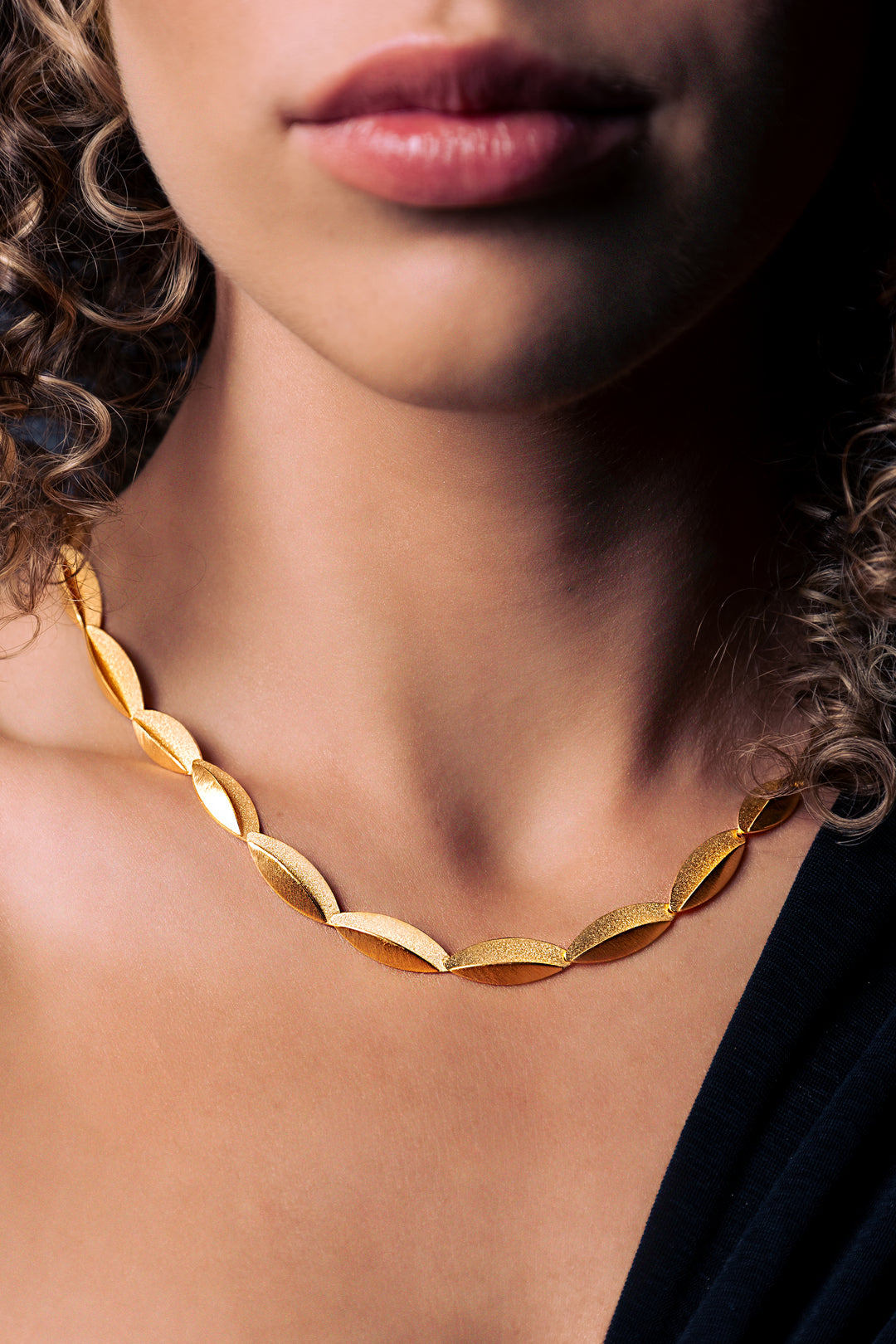 woman wearing folded gold necklace 